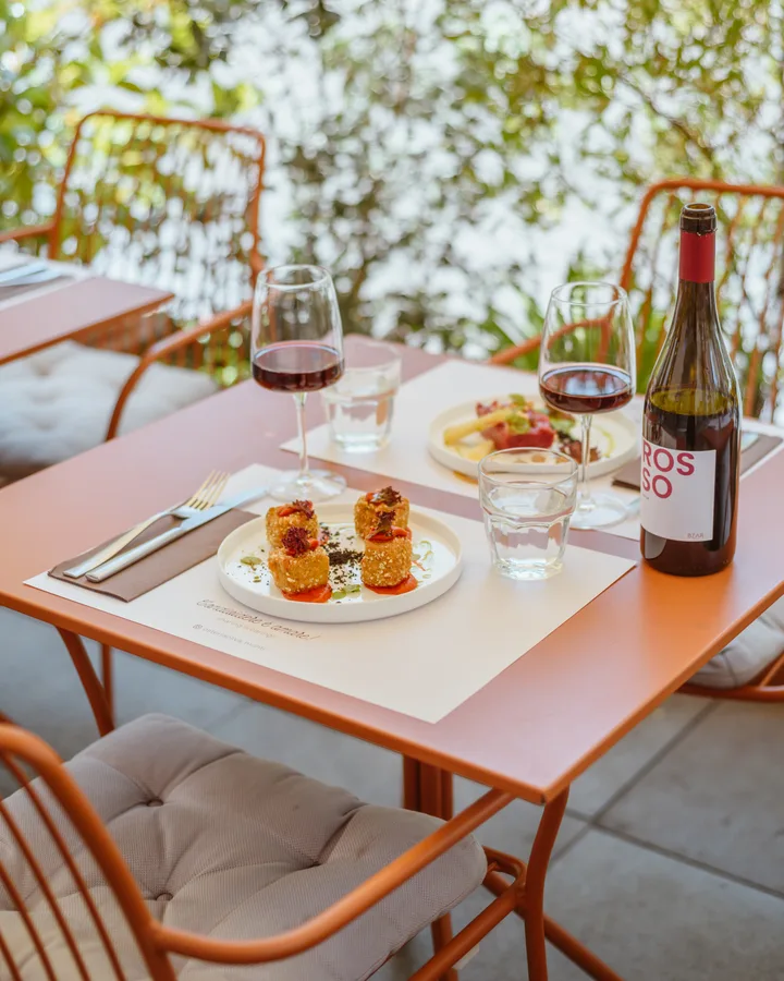 Croquettes, tartare and BZAR red wine on an outdoor table at Osteria Oliva in Monti
